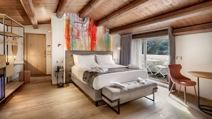 A modern bedroom with a large bed, a wooden ceiling, a view of the outdoors, and a small table with a chair. - Dimora Bonafede Ibla Design Rooms (Ragusa)