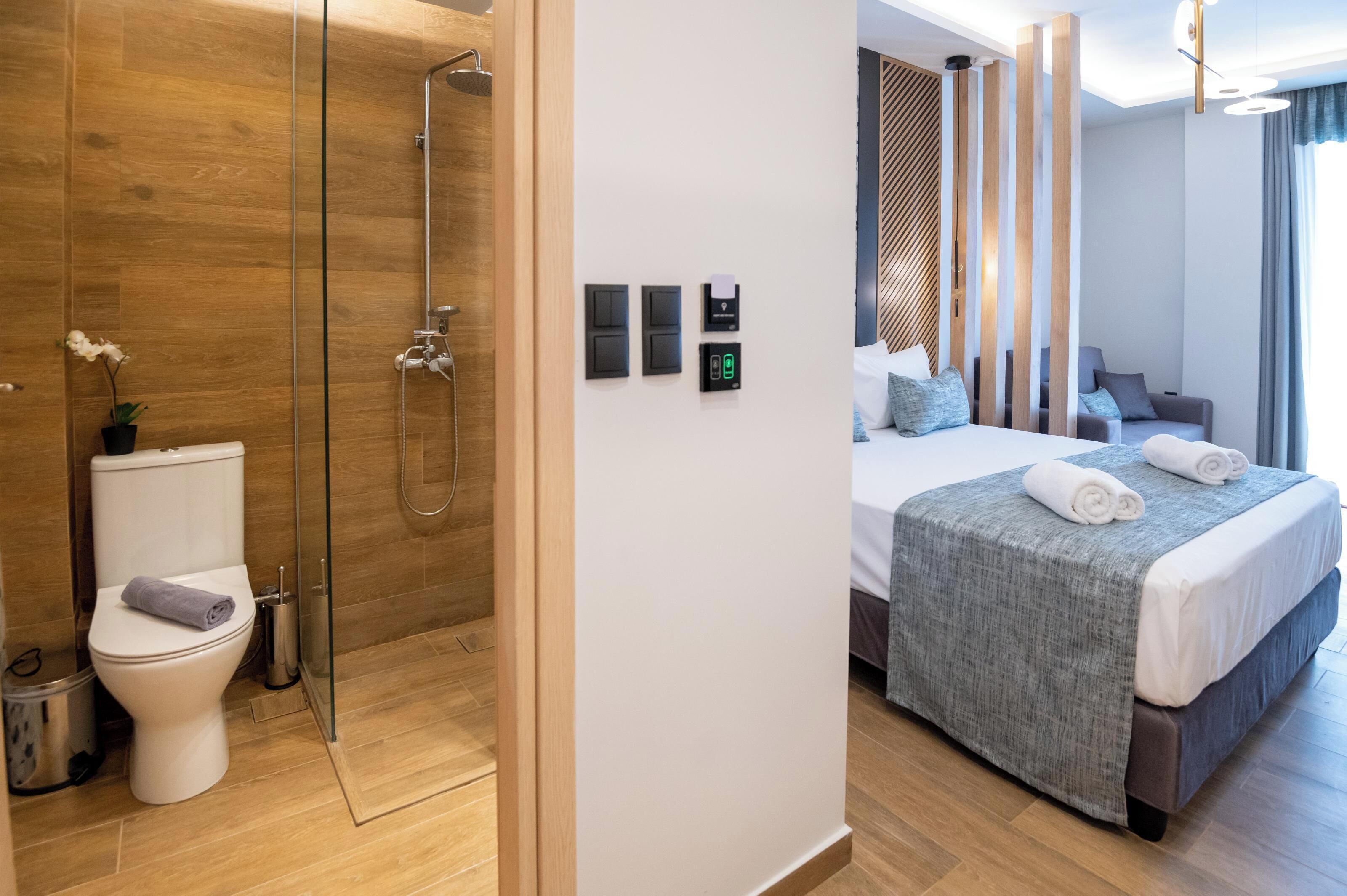 A modern hotel room with a shower, toilet, and bed.