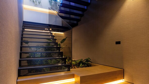 A modern staircase with integrated lighting and a plant on the landing. - Feelathome Nervión Apartments (Seville)