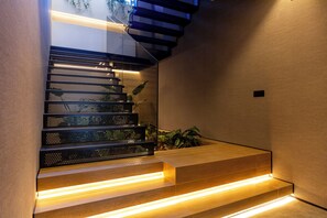 A modern staircase with integrated lighting and a plant on the landing. - Feelathome Nervión Apartments (Seville)