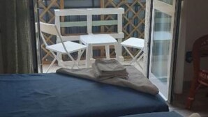 A room with a bed, a table, and chairs. - Comeacasa. (Salerno)