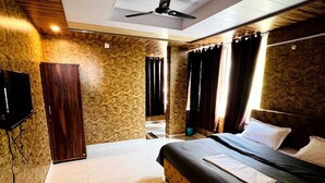 Un dormitorio con cama, ventilador de techo, televisor y suelo de baldosas.