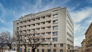 A multi-story building with a flat facade, multiple balconies, and a parking sign. - Carignano Luxury Suite by Wonderful Italy (Genoa)