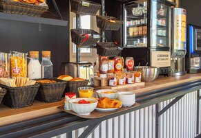 Un bufé de desayuno con diversas opciones de comida y bebidas.
