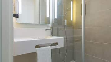Een douche, handdoeken, zeep, shampoo