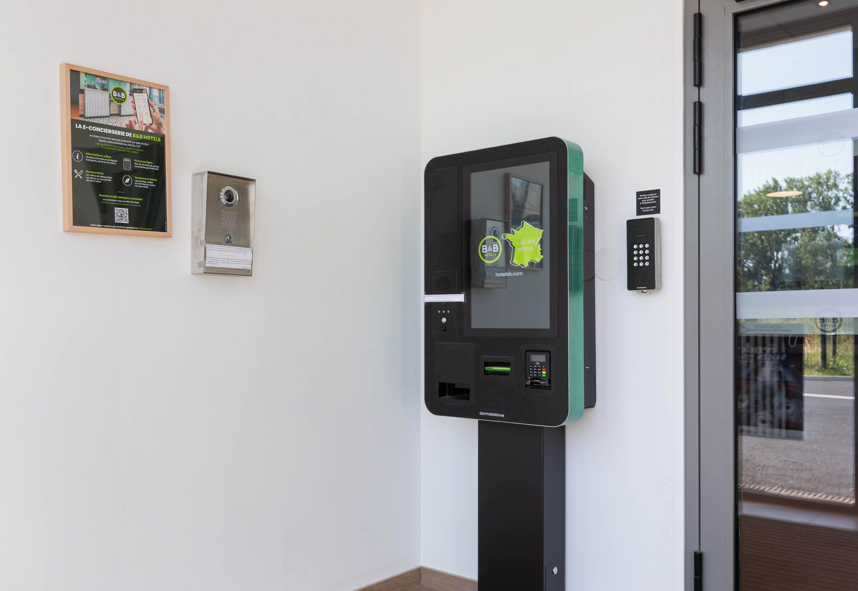 Un kiosque en libre-service doté d’un écran, d’un lecteur de cartes et d’un clavier, probablement utilisé pour l’enregistrement des clients d’hôtel ou pour fournir des informations.