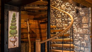 A wooden spiral staircase with a stone wall backdrop. - Bi Abant Masali Village Hotel (Bolu)