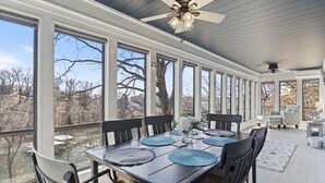 A dining area with a large table, chairs, and a ceiling fan. - Spacious Home & Lake Access, Lake Views Throughout (Lake Ozark)