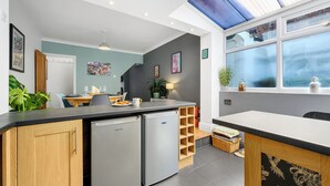 Una cocina moderna con lavavajillas integrado, un comedor con mesa y sillas, y un ventanal con vistas.