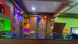 A bar area with shelves of liquor bottles and a counter.