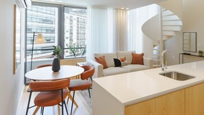 A modern apartment with a kitchen, dining area, and a spiral staircase. - Feel Porto Corporate Housing Boavista I (Porto)