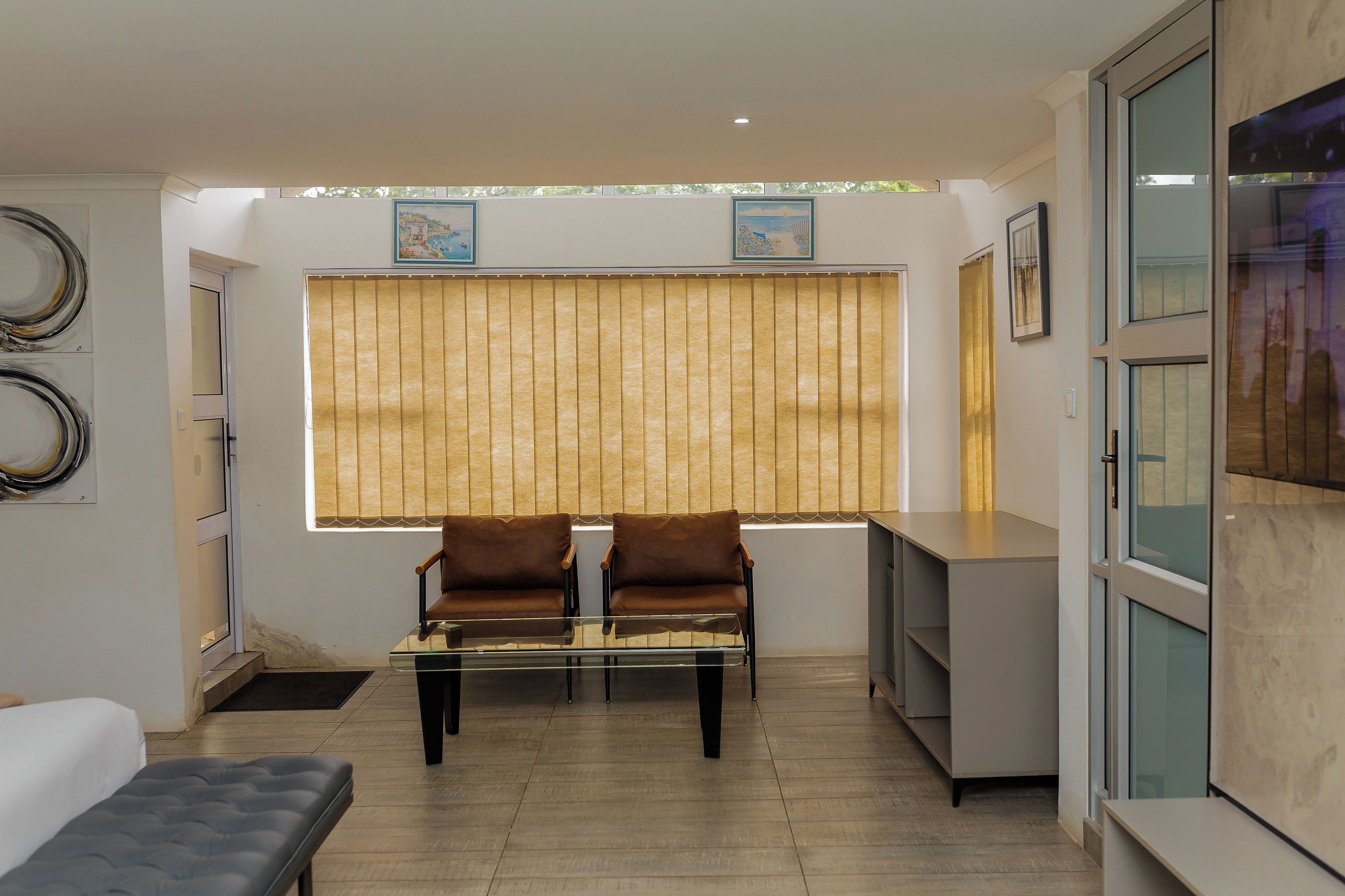 A modern living room with a sofa set, a coffee table, and a dining area with a counter.