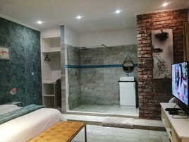 Un baño moderno con ducha, lavamanos y televisión.