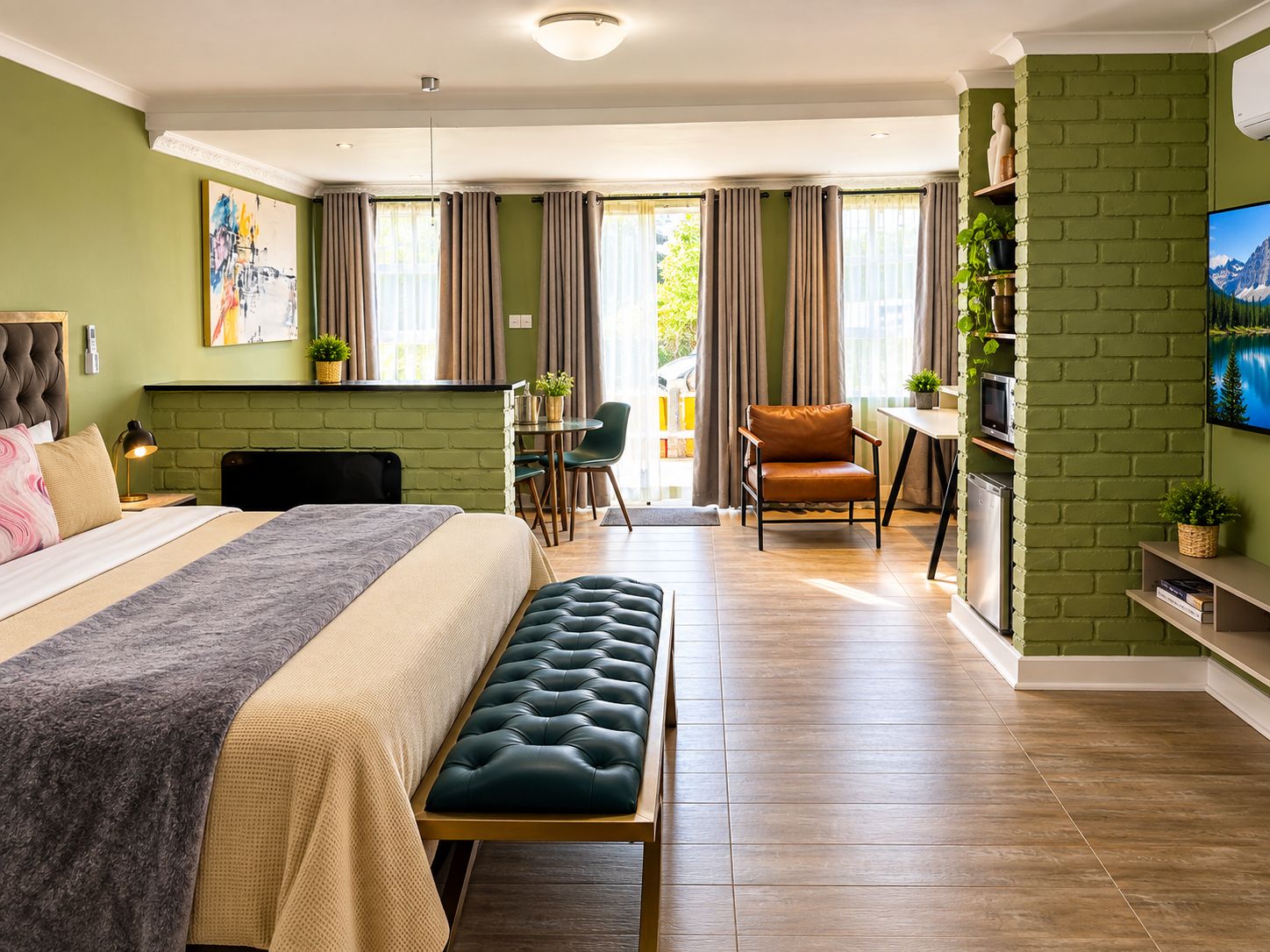 Une chambre d’hôtel moderne équipée d’un lit, d’une banquette, d’un bureau et d’une chaise.