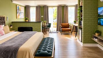 Une chambre d’hôtel moderne équipée d’un lit, d’une banquette, d’un bureau et d’une chaise.