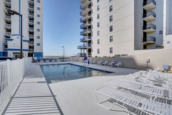 A pool area with lounge chairs and a clear sky. - Perdido Dunes Tower 1W by Liquid Life (Orange Beach)