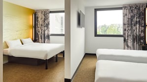 A hotel room with two beds, a large window with curtains, a flat-screen TV, and a yellow accent wall. - B&B Hotel Paris Clichy-Sous-Bois (Clichy-Sous-Bois)