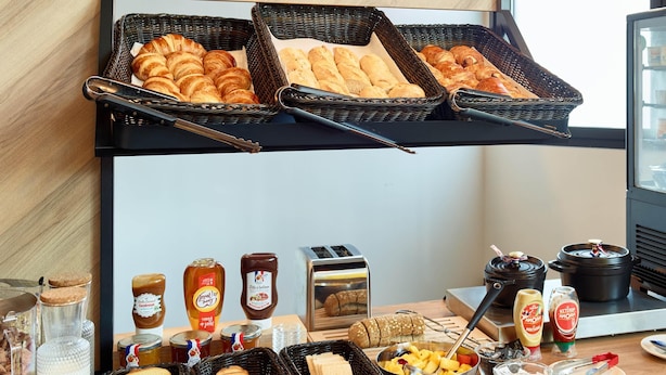 A breakfast buffet with bread, pastries, jams, and condiments. - B&B Hotel Paris Clichy-Sous-Bois (Clichy-Sous-Bois)