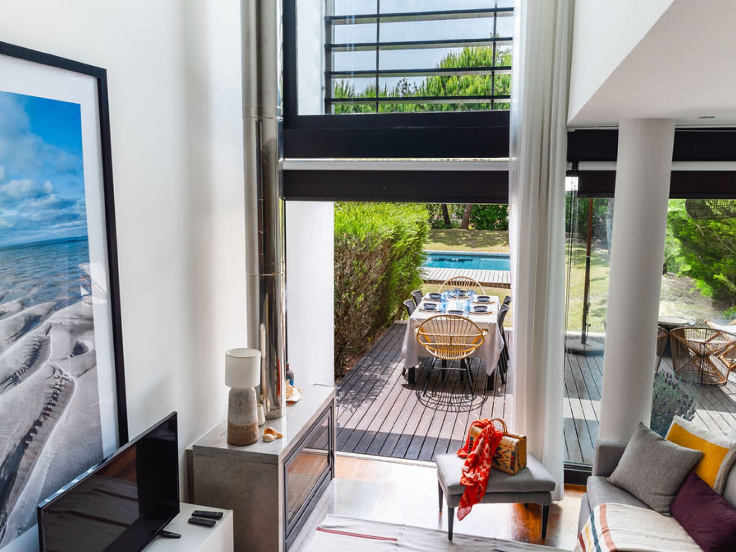 Un interior moderno con un amplio ventanal con vistas a una piscina y un jardín.