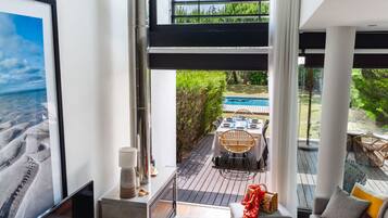 Un interior moderno con un amplio ventanal con vistas a una piscina y un jardín.