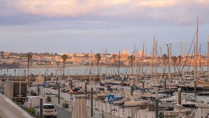 A marina with numerous boats docked, a cityscape in the background, and a clear sky. - Historic Center Cascais Bolina 2 (Cascais)