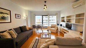 A living room with a sofa, armchairs, a coffee table, and a TV. There is a dining area with chairs and a table. - Lisbon City Center Dream s (Lisbon)