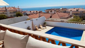 A rooftop pool with a view of the sea and neighboring buildings. - Sunset Terrace Pool (Mafra)