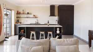 A modern kitchen with a central island, bar stools, and built-in shelves. - Sunset Terrace Pool (Mafra)