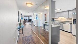 A modern kitchen with grey cabinets, a stainless steel refrigerator, and a glass partition. - SD 410: Seaside Summit - Watch the Sun Sink into the Gorgeous Gulf! (Fort Walton Beach)