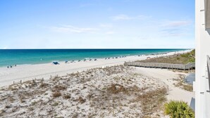 A beach view with a wooden boardwalk, sandy beach, and ocean. - SD 410: Seaside Summit - Watch the Sun Sink into the Gorgeous Gulf! (Fort Walton Beach)
