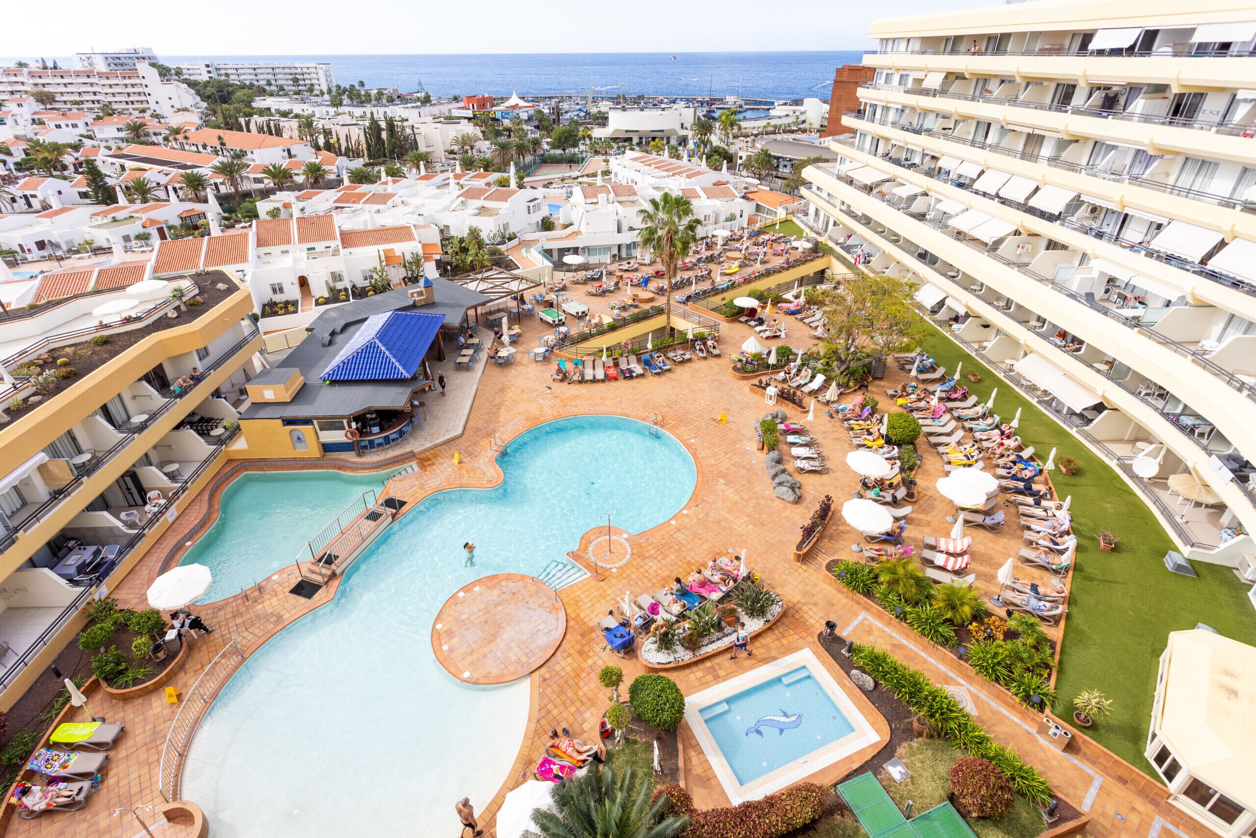 A resort with multiple swimming pools, sun loungers, and a large outdoor area.