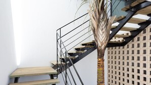 A staircase with wooden steps and a metal railing, leading to a landing with a palm tree and a lattice wall. - Marvelous home with private pool (San Miguel de Abona)