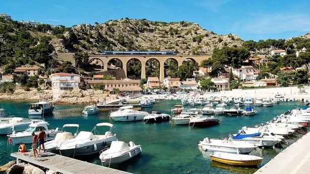 A marina with boats docked, a train bridge, and buildings on a hillside. - Vacances à 10 Minutes des Plages, Avec BBQ et Piscine (Châteauneuf les Martigues)