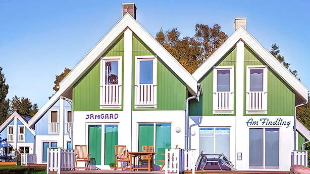 A row of three-story houses with green and white facades, each with a balcony and a small porch. - Ferienhaus Ostseebad Breege (Ostseebad Breege)
