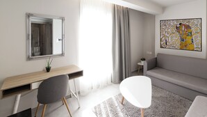 Ein modernes Wohnzimmer mit einem grauen Sofa, einem weißen Sessel, einem Holztisch mit einem Spiegel und einem grauen Teppich.