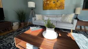 Una sala de estar moderna con sofá, mesa de centro y plantas decorativas.