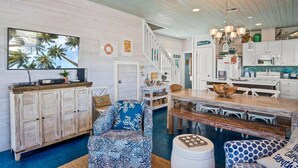 A spacious kitchen with white cabinets, a wooden dining table, and a large island. - `Escape to Endless Summer: Morning coffee, and BBQs, with access to two community pools for endless family fun!` (Port Aransas)