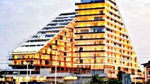 Un hôtel à plusieurs étages doté d’une architecture originale aux lignes angulaires, avec des balcons et une terrasse sur le toit.