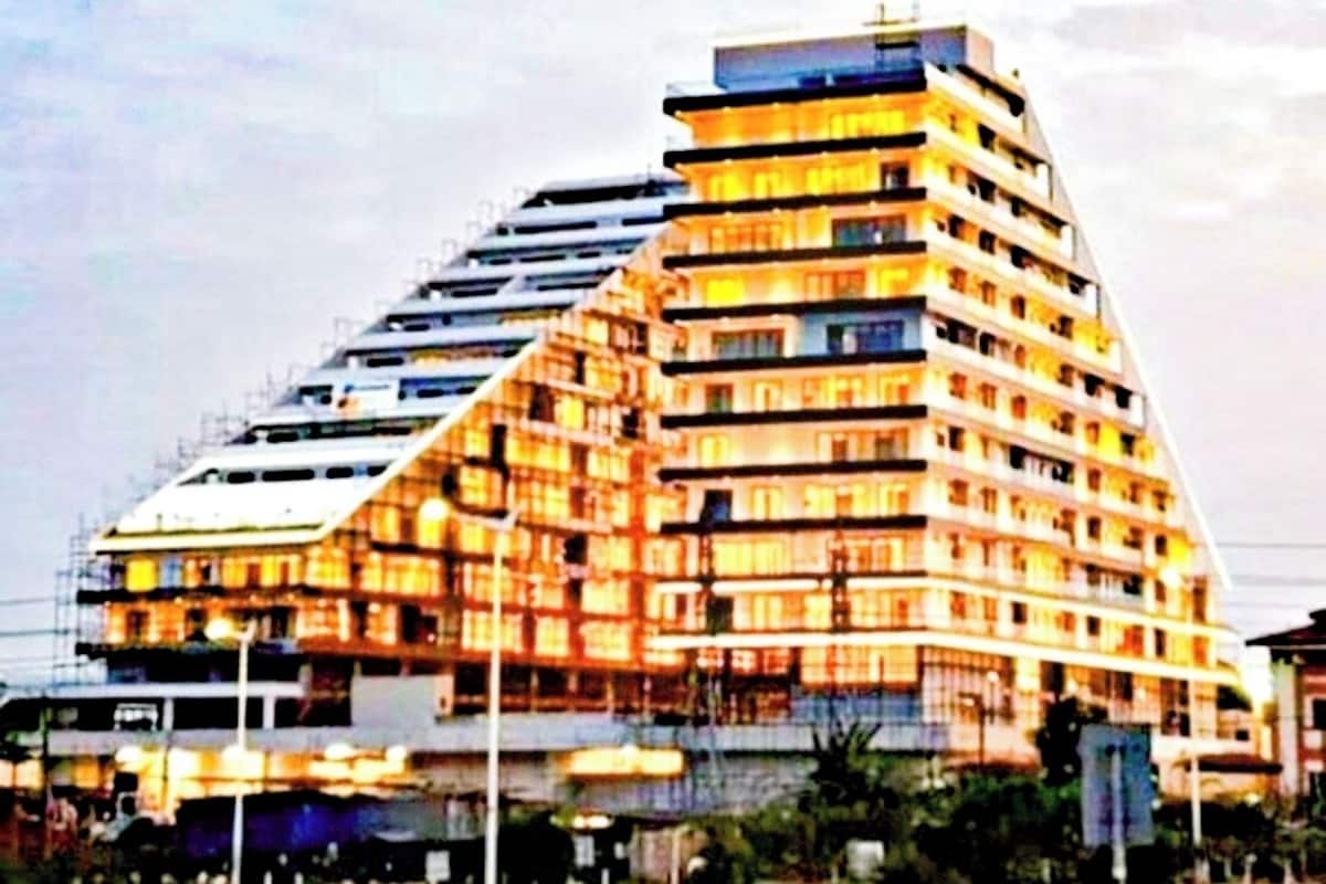 Ein mehrstöckiges Hotel mit einem markanten, winkelförmigen Design, mit Balkonen und einer Dachterrasse.