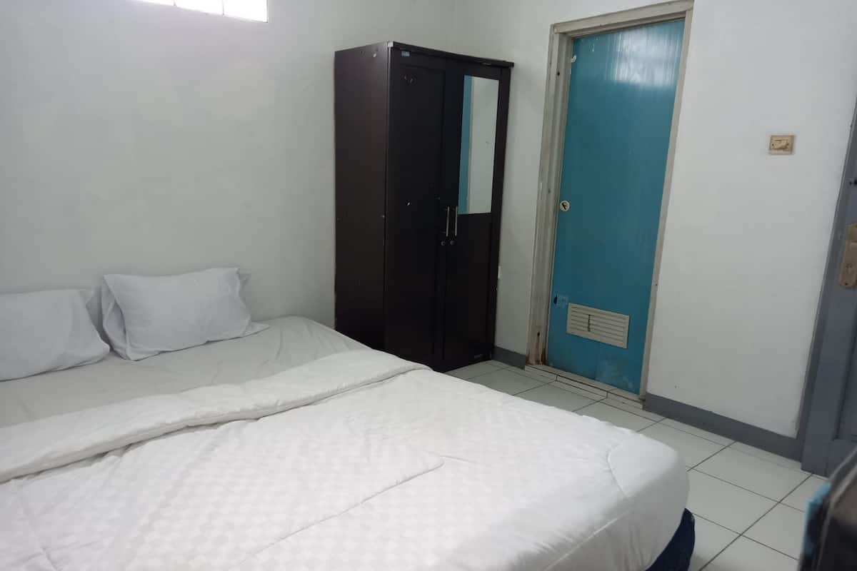 Ein Schlafzimmer mit einem Bett, einem Kleiderschrank und einer Tür.