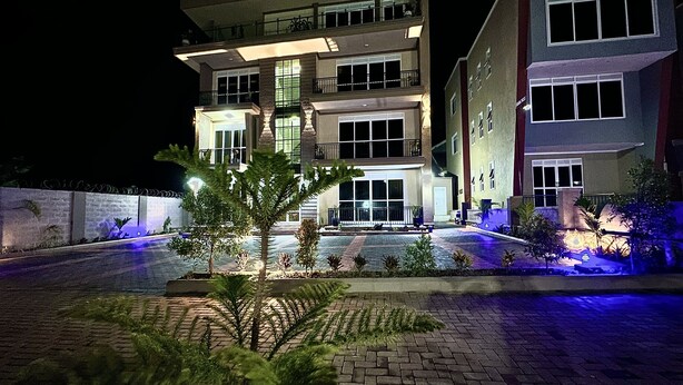 A multi-story hotel with a well-lit entrance and a landscaped courtyard.