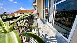 A balcony with a view of neighboring buildings and a clear sky.