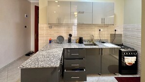 A modern kitchen with granite countertops, stainless steel appliances, and a large island with drawers.