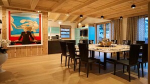 A dining area with a wooden ceiling, a large painting, and a table set for six. - Impeccable 4-bed Villa in Cadin di Sotto (Cortina d'Ampezzo)