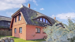A red brick house with a steeply pitched roof and a chimney. - Ferienwohnung Mönchgut (Mönchgut OT Alt Reddev)