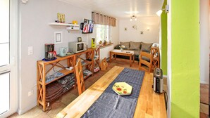 A compact living space with a dining area, a sofa, and a television.