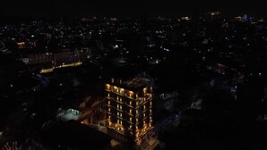A high-rise building with multiple floors, illuminated windows, and a central courtyard. - Hotel Kesu Home (Kathmandu)