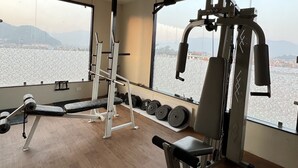 A gym with exercise equipment, a bench, and dumbbells. - Hotel Kesu Home (Kathmandu)