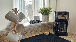 A kitchen with a coffee station, a coffee maker, and a window with curtains. - Charming Farmhouse in Oneonta, NY, 2 Mins away from Cooperstown All Star Village (Oneonta)