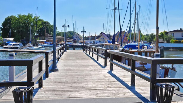 A wooden pier leading to a marina with boats docked on both sides. - Ferienhaus Lassan bei Wolgast (Lassan bei Wolgast)